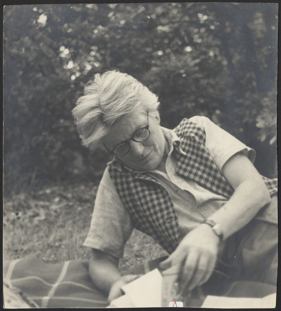 Edna Walling lying down reading a book