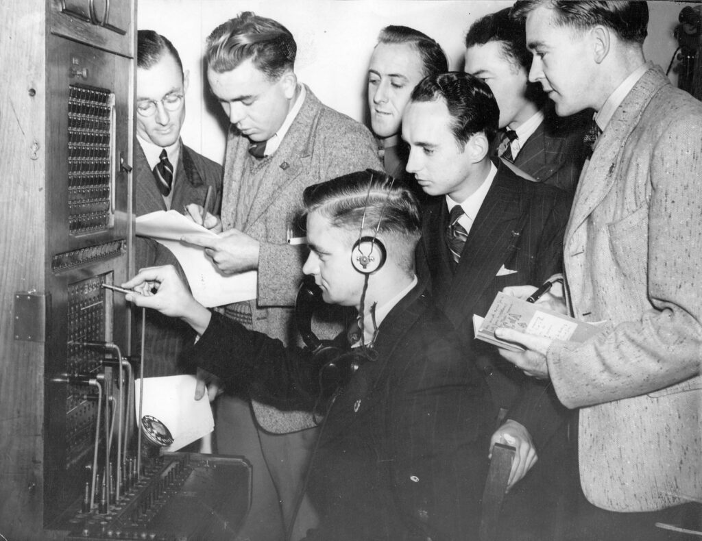 black and white photo of men in telephone exchange from 1946