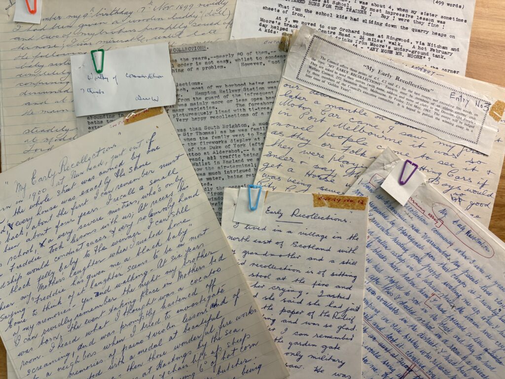 Group photograph of some of the essays, including handwritten and typed examples.