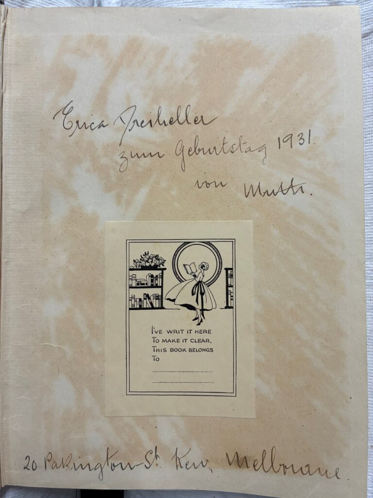 photo of book page featuring handwritten inscription and bookplate with an image of a woman reading a book on it and the words "I've writ it here, to make it clear, this book belongs to ,,,"