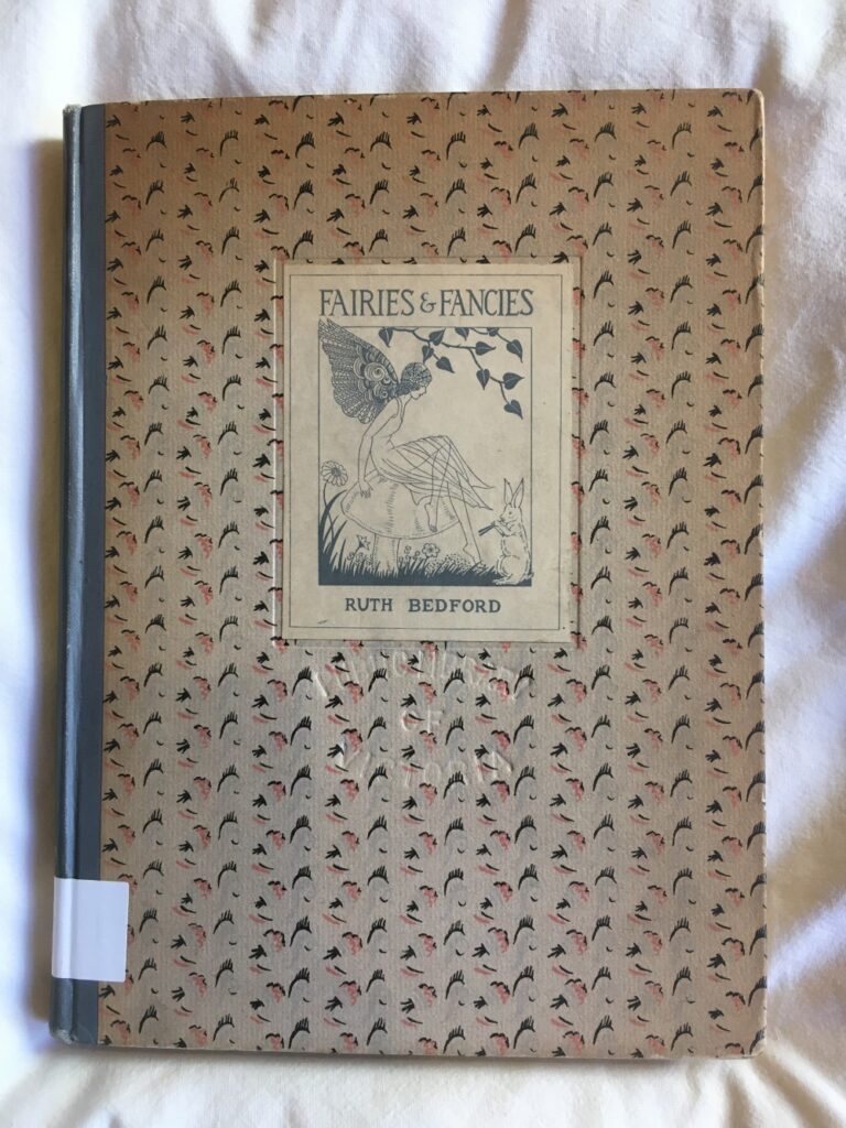 Front cover of book Fairies & Fancies by Ruth Bedford. Patterned cover with black and white image of fairy with wings sitting on a large mushroom while a rabbit to the right plays a pipe.